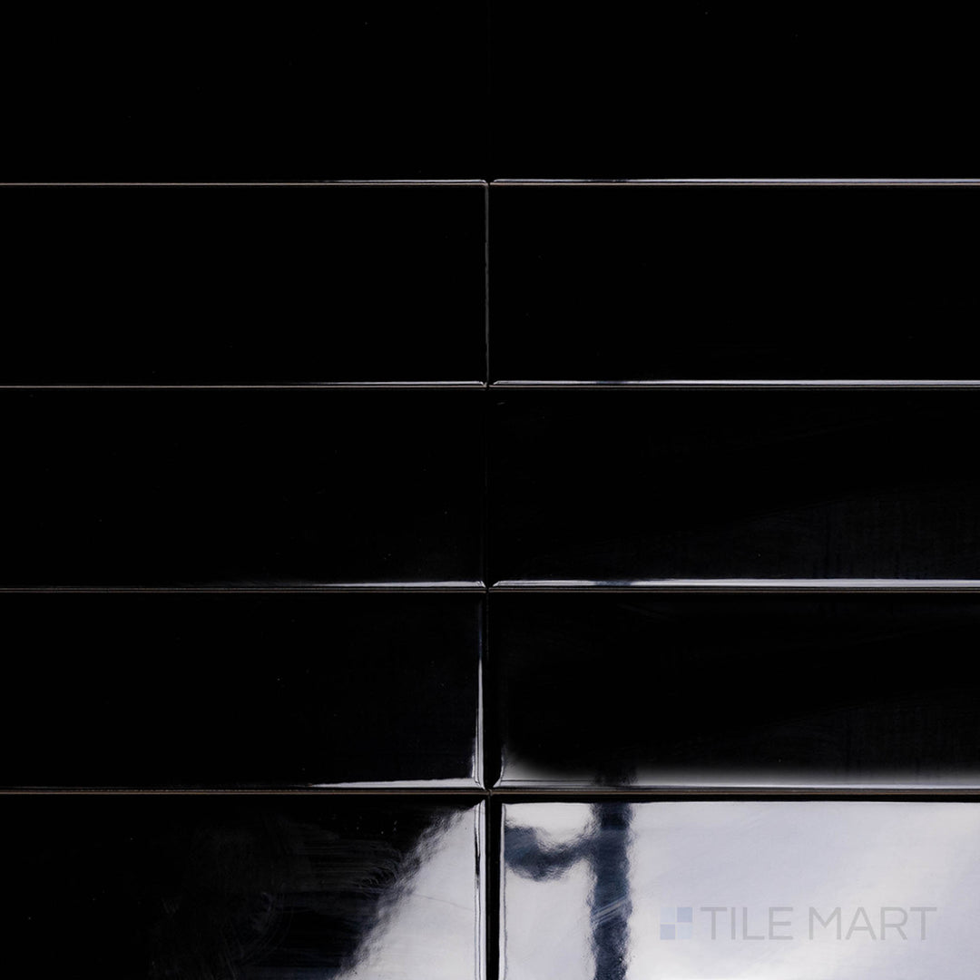 An overhead view of the Block Negro 2x10 inch bright ceramic tile highlights its dramatic black shade and smooth, reflective glaze, perfect for a bold, modern style.