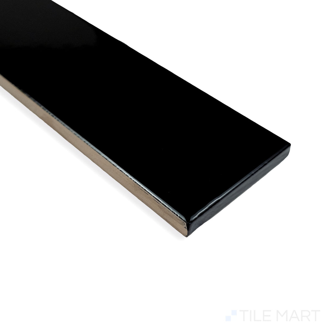 Corner view of Block Negro 2X10 bright ceramic tile, emphasizing its bold black tone, smooth reflective glaze, and precise tile arrangement.