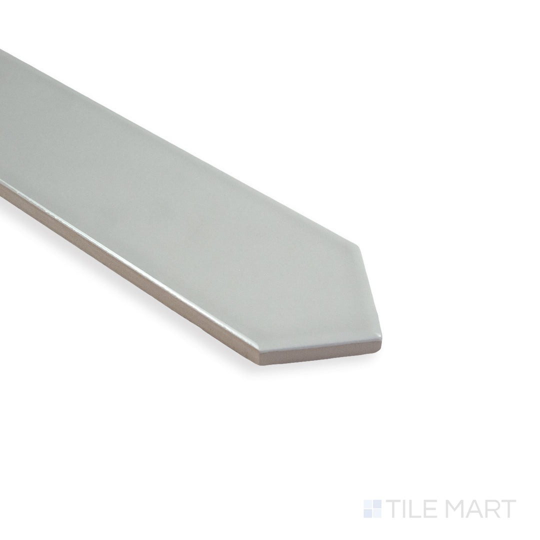 Angled perspective of Block Gris 2X10 Arrow bright ceramic tile, showcasing its light-gray hue, polished finish, and the unique arrow pattern transition at the corner.