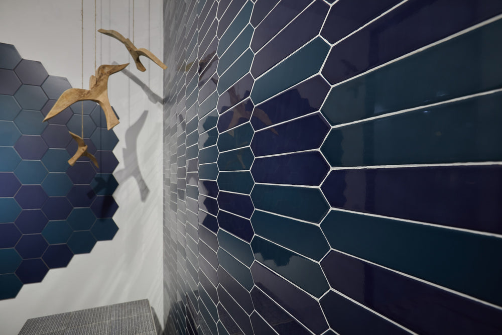 Block Verde 2x10 Arrow Bright ceramic tile shown in a styled space, capturing its deep green glaze and linear arrow design with a reflective surface.