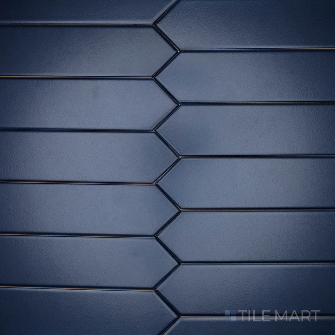 A high-angle perspective of the Block Azul 2x10 inch Arrow matte ceramic tile emphasizes its bold blue hue with a soft, non-glossy texture, perfect for geometric layouts.