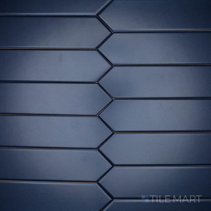A high-angle perspective of the Block Azul 2x10 inch Arrow matte ceramic tile emphasizes its bold blue hue with a soft, non-glossy texture, perfect for geometric layouts.