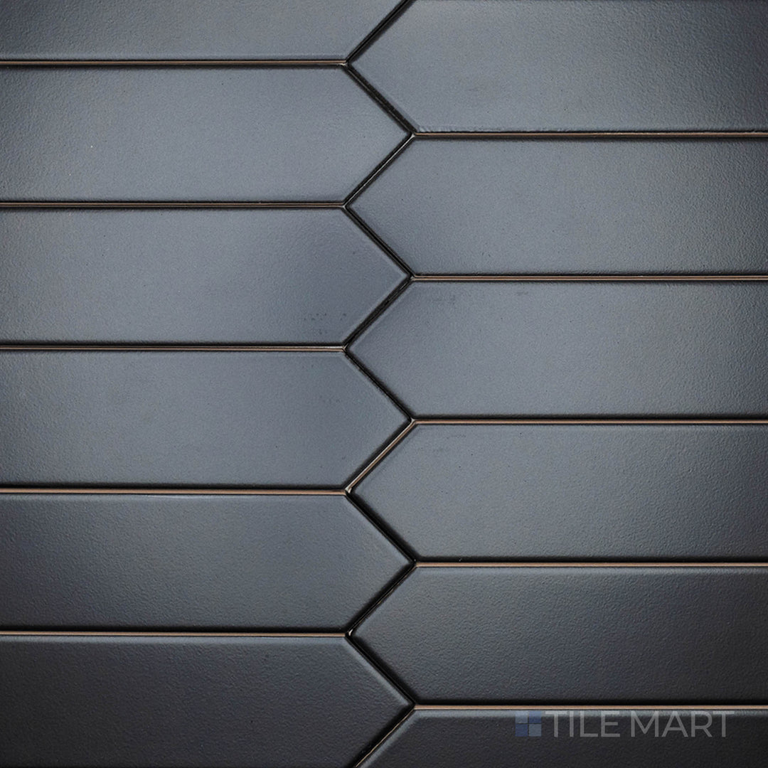 This top-down shot of the Block Negro 2x10 inch Arrow matte ceramic tile reveals its dramatic black color and matte texture, ideal for creating striking geometric designs.