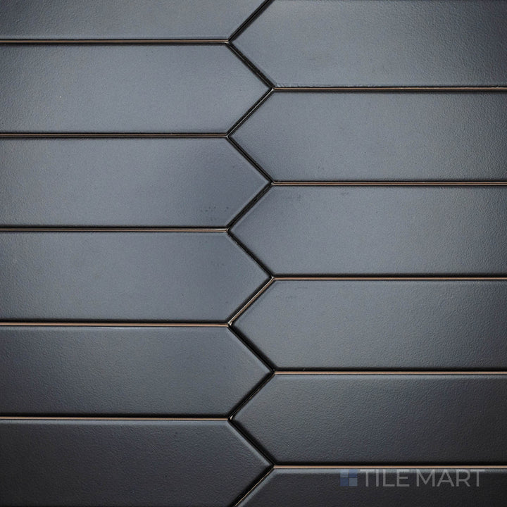 This top-down shot of the Block Negro 2x10 inch Arrow matte ceramic tile reveals its dramatic black color and matte texture, ideal for creating striking geometric designs.