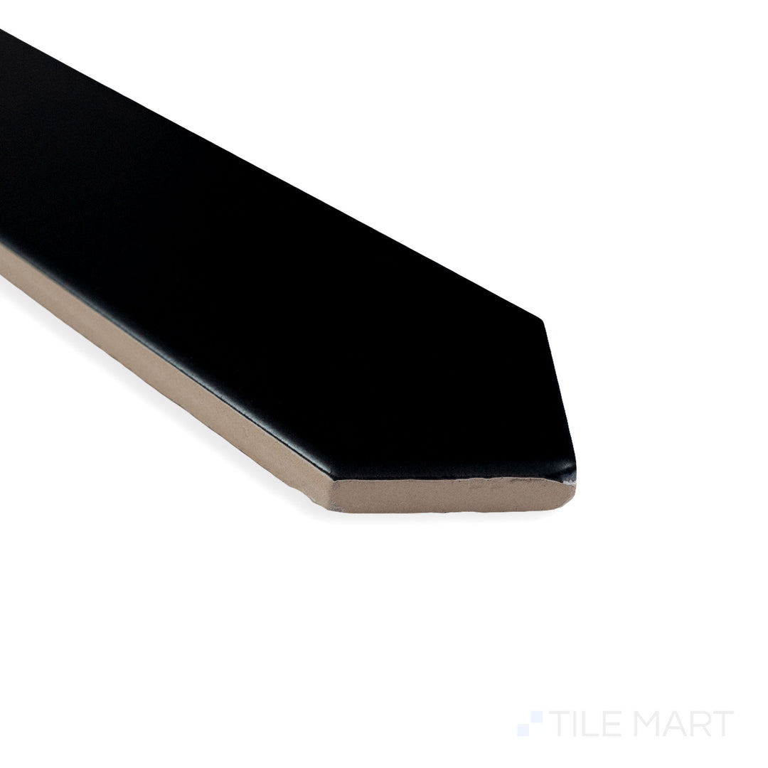 Corner-focused image of Block Negro 2X10 Arrow matte ceramic tile, displaying its deep black shade, velvety finish, and arrow pattern converging at the edge.