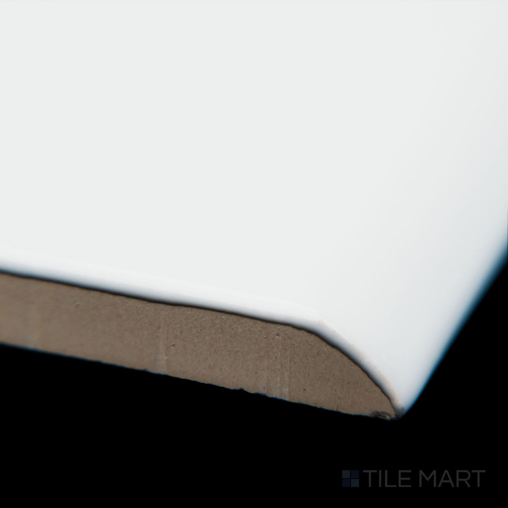 A detailed corner view of Block Blanco 2x10 bright ceramic bullnose, showcasing its crisp white color, smooth rounded edge, and high-gloss surface.