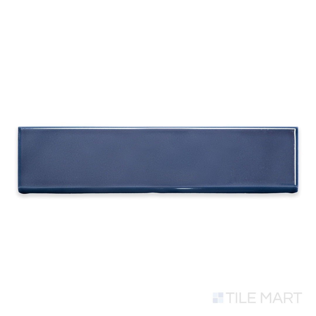 A detailed top-down view of Block Azul 2x10 bright ceramic bullnose, emphasizing its deep blue shade and reflective surface.