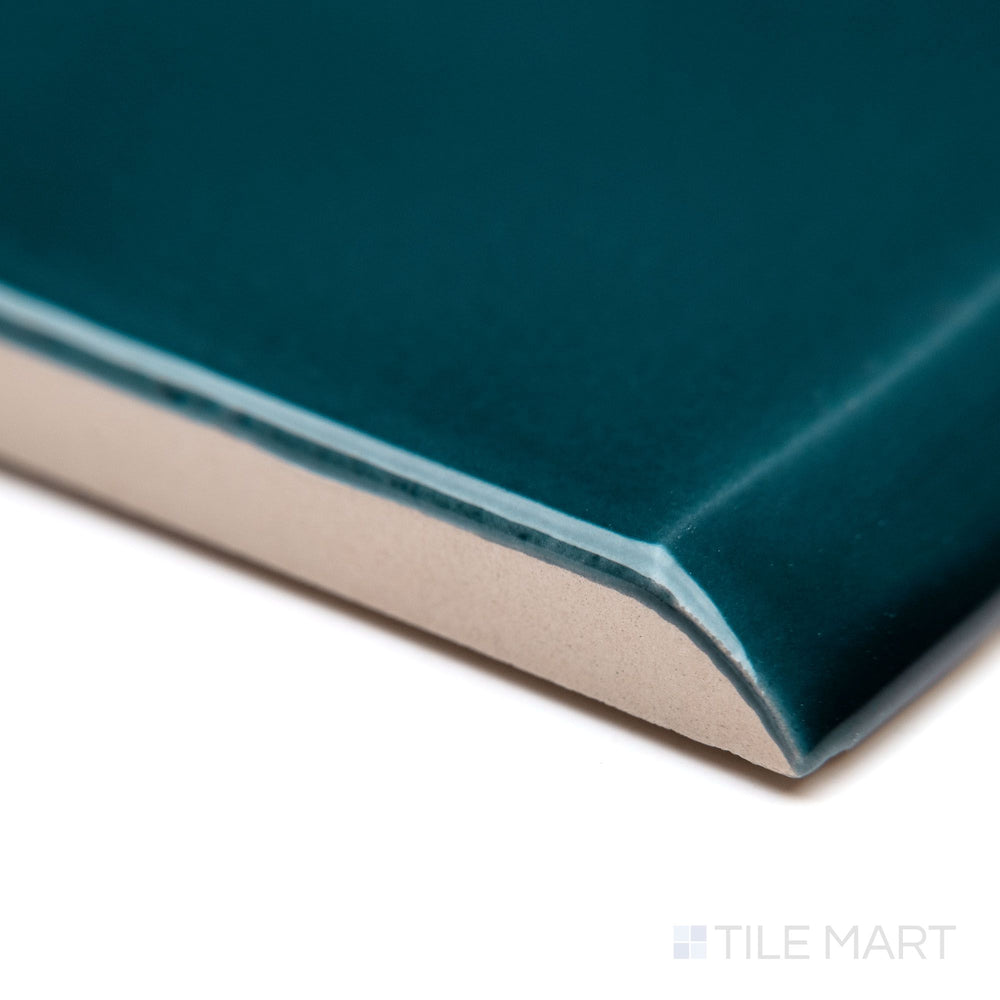 A sharp corner view of Block Verde 2x10 bright ceramic bullnose, emphasizing its vibrant green color, rounded edge, and smooth polished glaze.