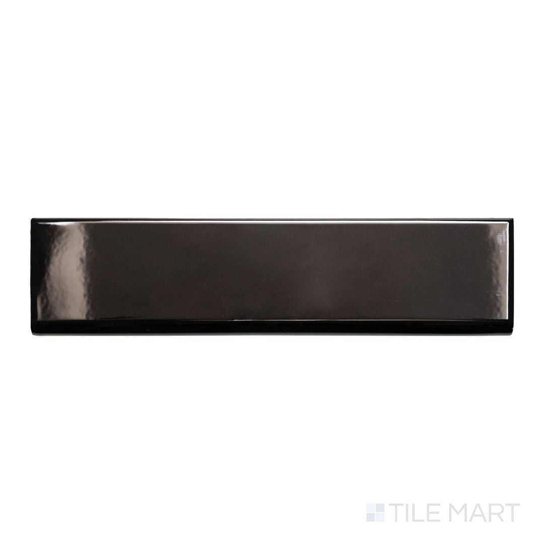 A top-down view of Block Negro 2x10 bright ceramic bullnose, showcasing its deep black color and glossy, reflective surface.