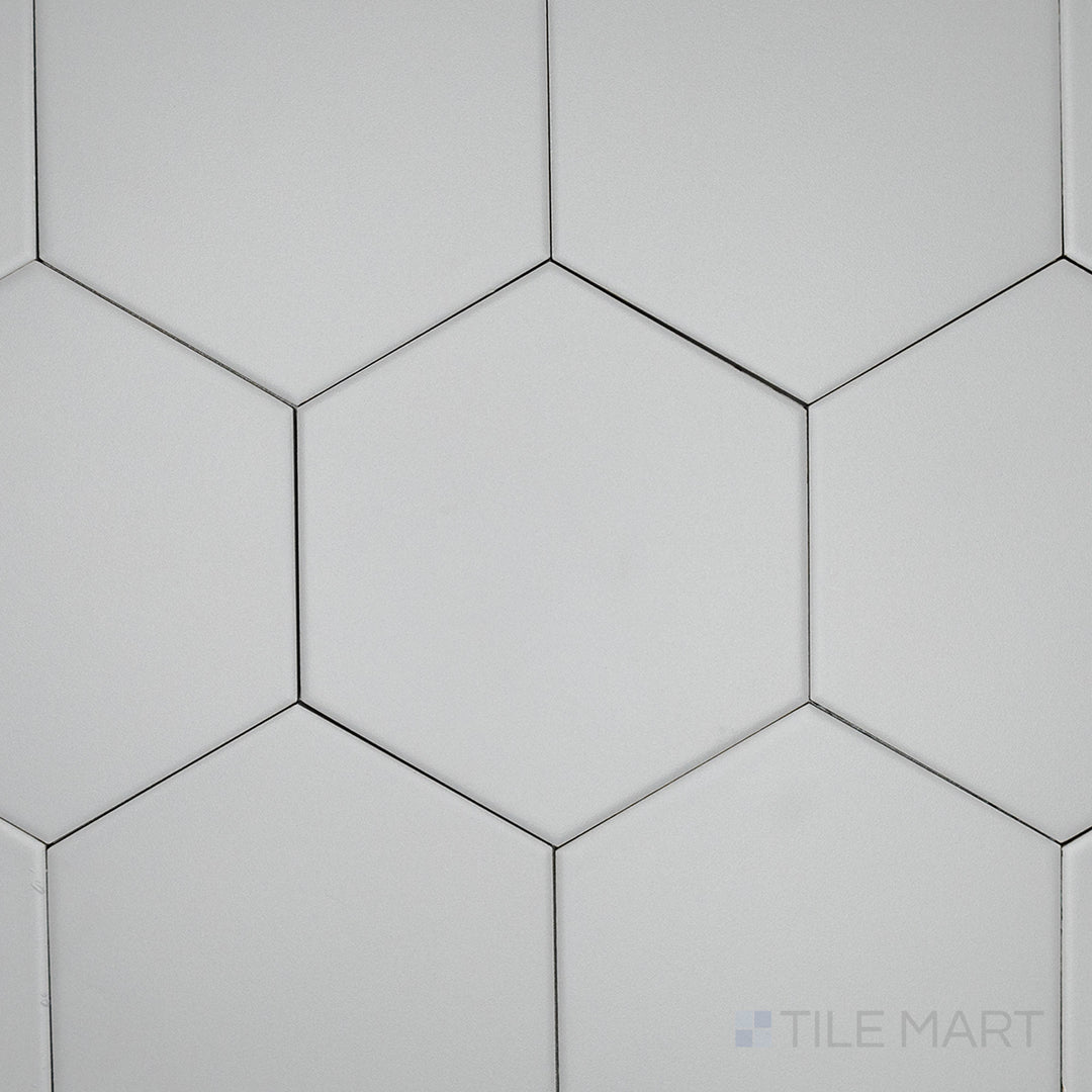 An overhead perspective of the Block Gris 6-inch hexagon matte glazed porcelain tile reveals its soft gray color and non-glossy surface, offering a versatile and contemporary feel.