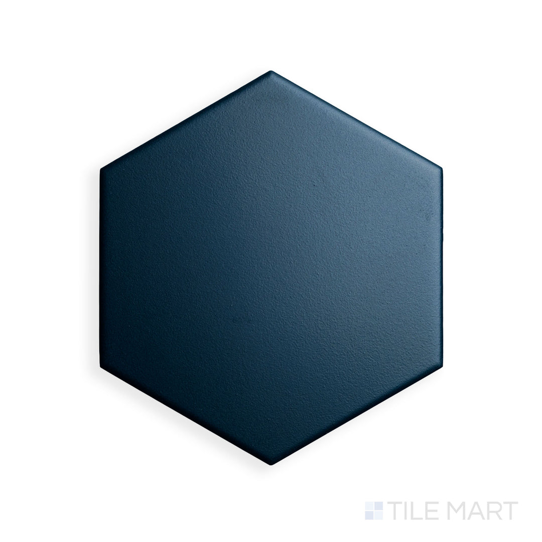 A close-up of Block Verde 6" Hexagon Matte Glazed Porcelain emphasizes its natural green hue with a sleek hexagonal shape, adding depth and contrast.