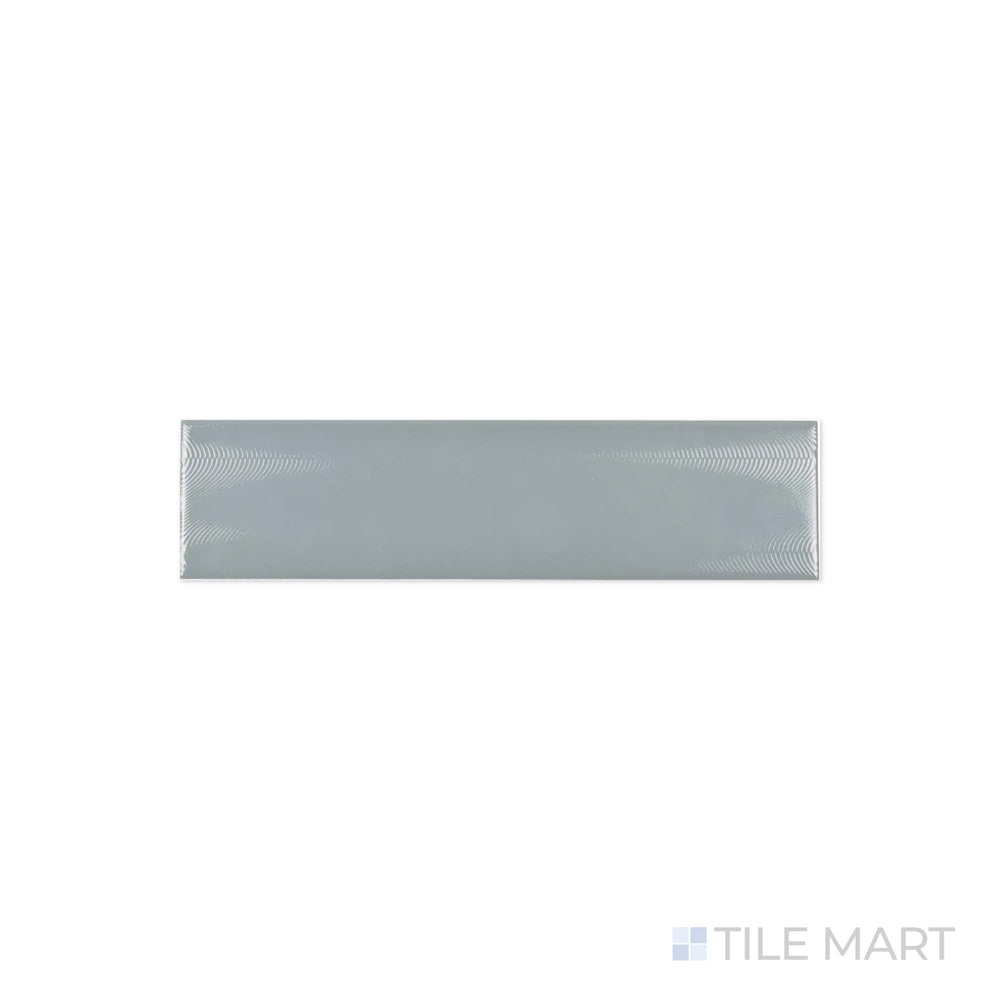 A macro shot of Cc Cosmos Mist 3X12 Bright Ceramic highlights its cool misty gray shade and high-gloss surface, ideal for modern and minimalist spaces.