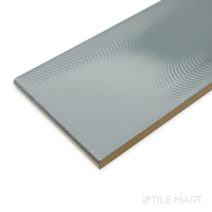 Angled perspective of Cc Cosmos Mist 3X12 bright ceramic tile, highlighting its soft misty gray tone, polished sheen, and seamless corner alignment.