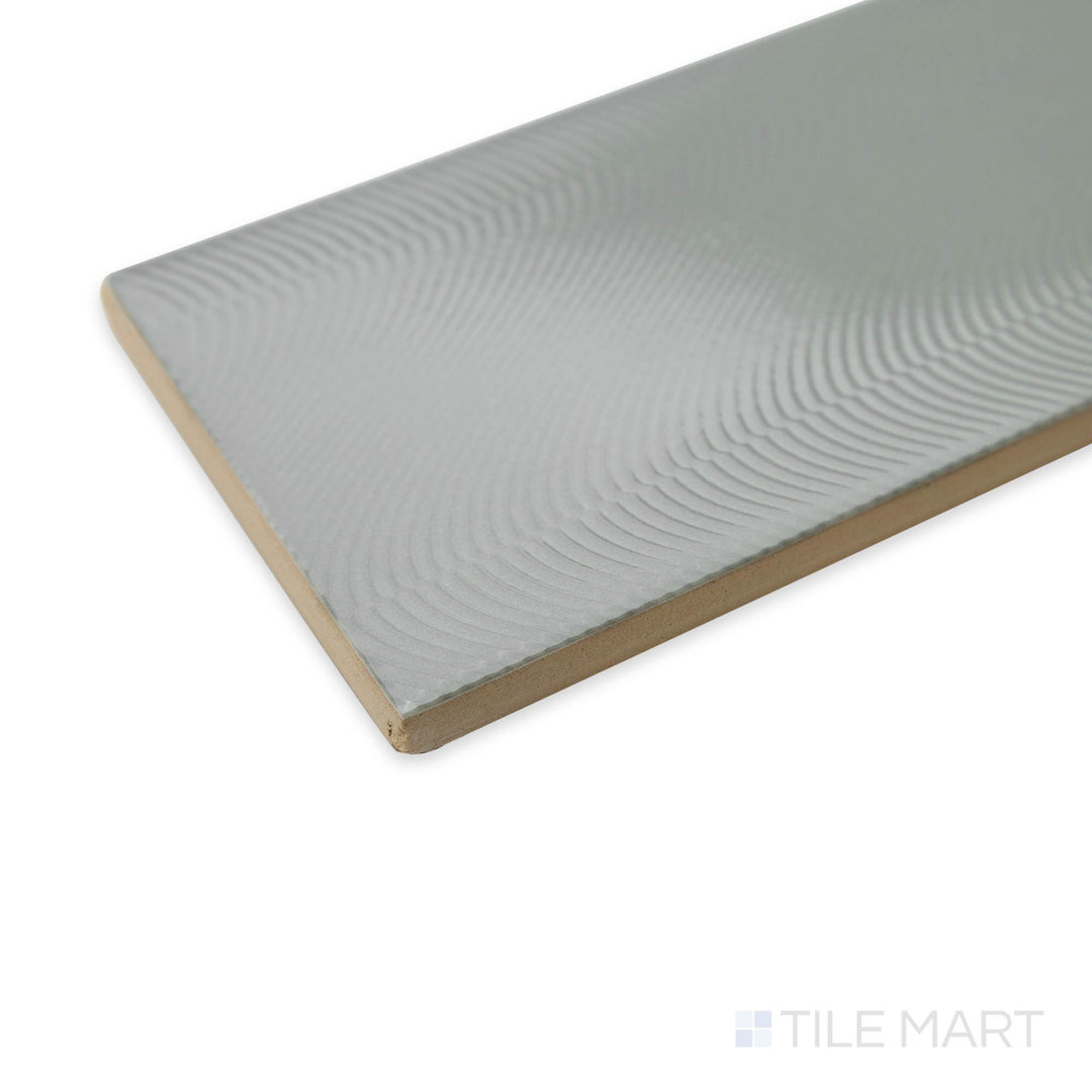 Close-up of Cc Cosmos Neu Gray 3X12 bright ceramic tile at the corner, featuring its sleek neutral gray shade, reflective glaze, and precise edge definition.