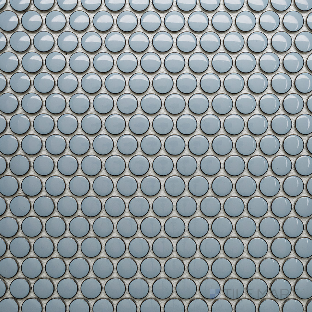 An overhead perspective of the Cc Mosaics Plus Sky Blue Penny Round bright glazed porcelain tile captures its cool blue tone and glossy penny-round layout, adding a fun and playful aesthetic.