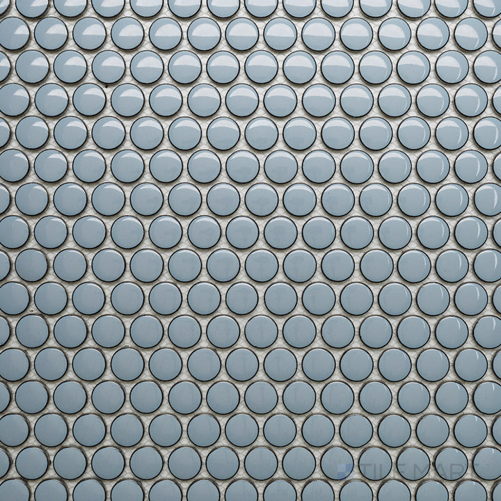 An overhead perspective of the Cc Mosaics Plus Sky Blue Penny Round bright glazed porcelain tile captures its cool blue tone and glossy penny-round layout, adding a fun and playful aesthetic.