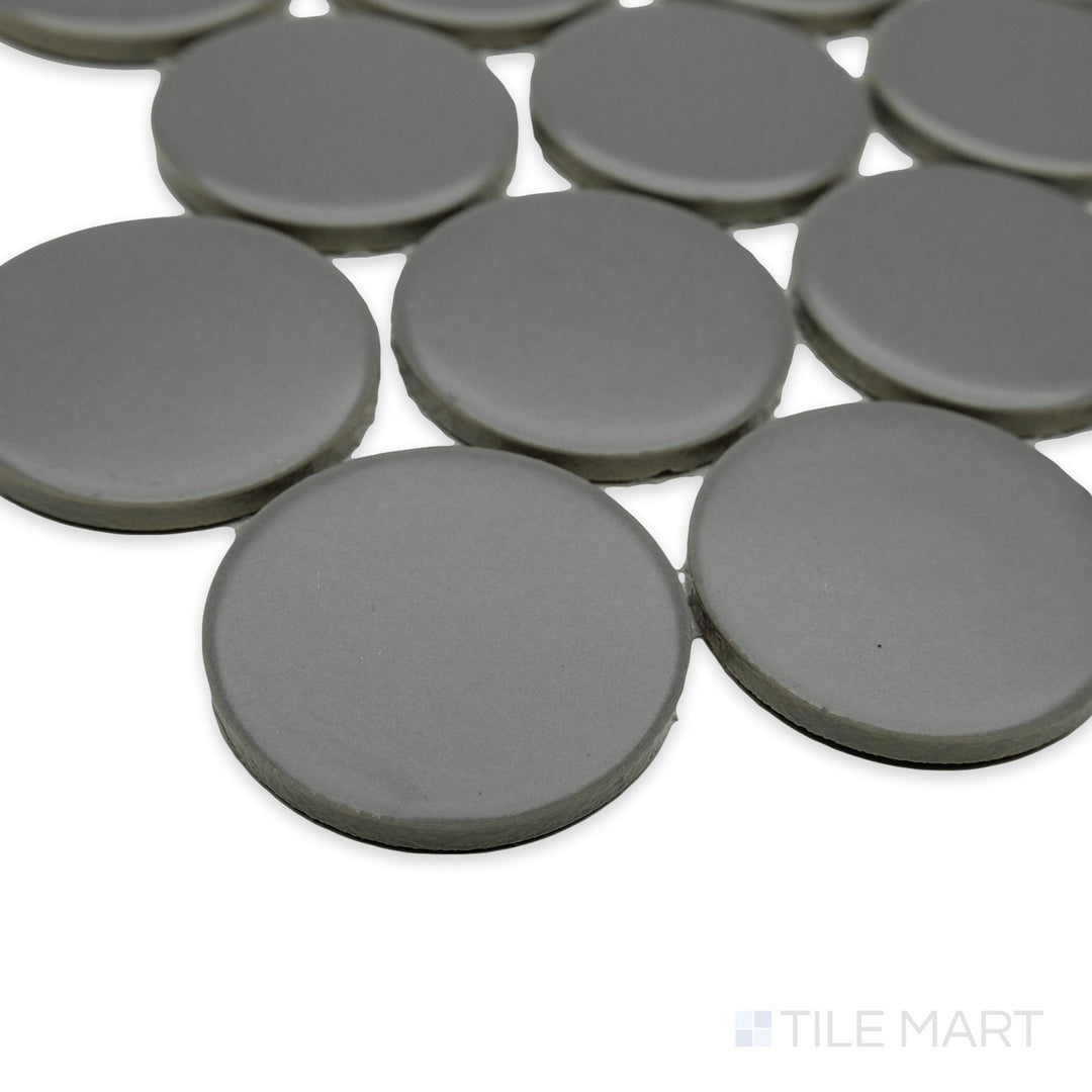 Close-up of Cc Mosaics Plus Gray 2" dots matte glazed porcelain tile at the corner, highlighting its neutral gray tone, smooth matte texture, and dot pattern alignment.