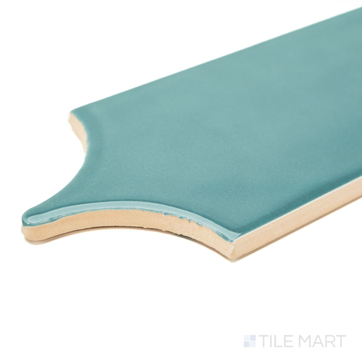 Feathers Seagrass 3x12 Bright ceramic tile shown from a corner perspective, showcasing its glossy green surface and feathered edge shape—ideal for decorative wall features.