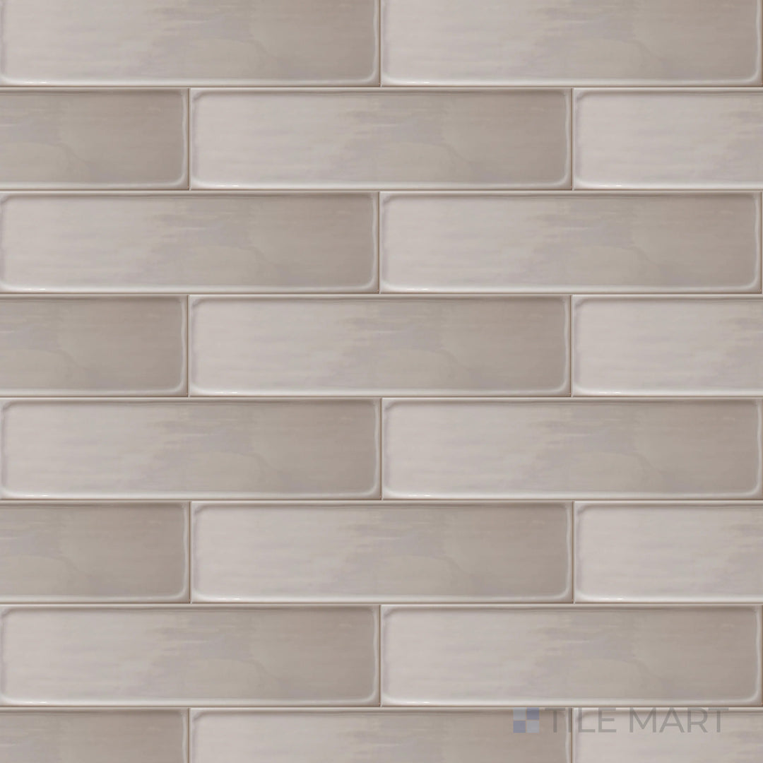 A top-down perspective of the Flow Tender Gray 3x12 inch bright ceramic tile showcases its soft gray tone and glossy sheen, creating a subtle yet refined interior touch.