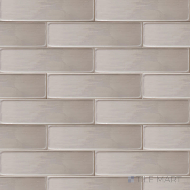 A top-down perspective of the Flow Tender Gray 3x12 inch bright ceramic tile showcases its soft gray tone and glossy sheen, creating a subtle yet refined interior touch.