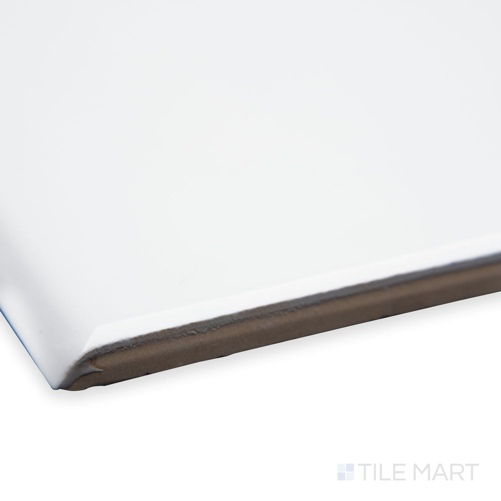 A corner view of Flow White 3x12 bright ceramic bullnose, emphasizing its clean white shade, smooth rounded profile, and polished ceramic sheen.