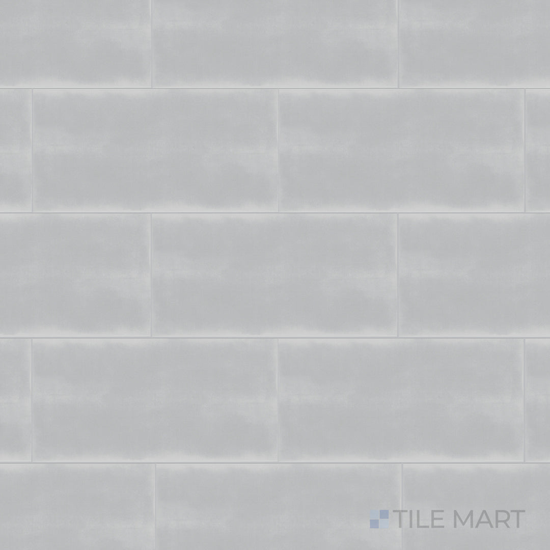 A top-down shot of the Maiolica Tender Gray 3x6 inch bright ceramic tile presents its soft gray shade with a reflective surface, adding a subtle and modern touch.