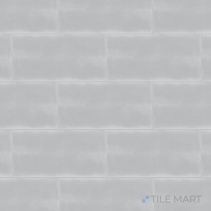 A top-down shot of the Maiolica Tender Gray 3x6 inch bright ceramic tile presents its soft gray shade with a reflective surface, adding a subtle and modern touch.