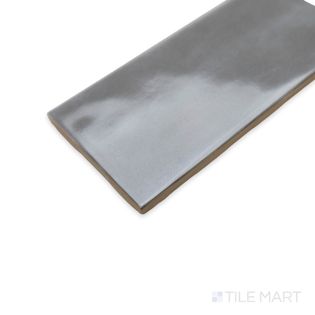 Maiolica Taupe 3x6 bright ceramic tile appears in a stylish corner perspective, featuring its rich earthy shade and a glossy finish that adds depth and elegance.