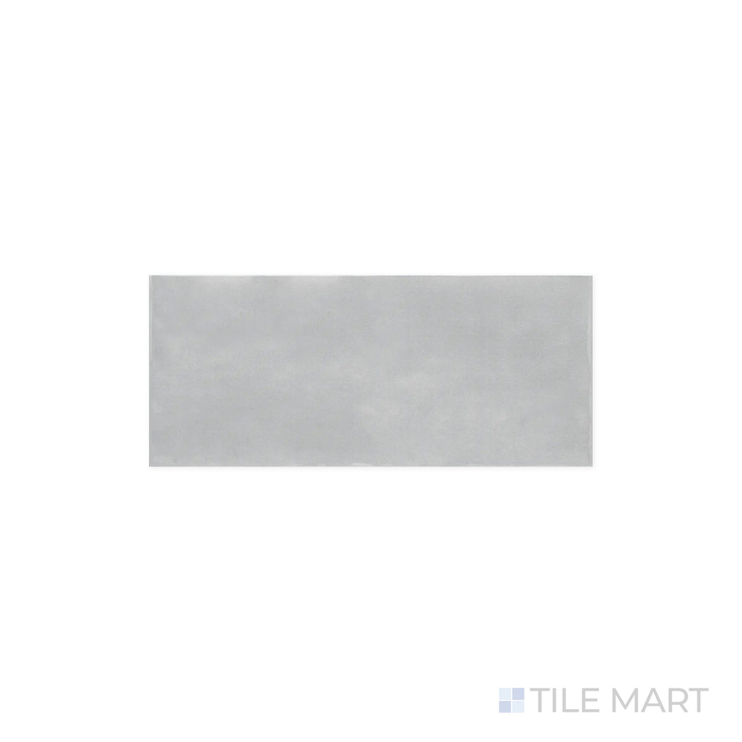 A focused look at Maiolica Tender Gray 4x10 Bright Ceramic Tile, where the soft gray hue is accentuated by the high-gloss finish. The smooth surface offers a refined, polished appearance.