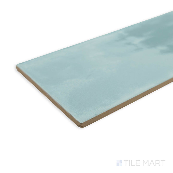 Maiolica Aqua 4x10 bright ceramic tile in a corner perspective, displaying its serene blue hue and polished finish that enhances depth and brightness.