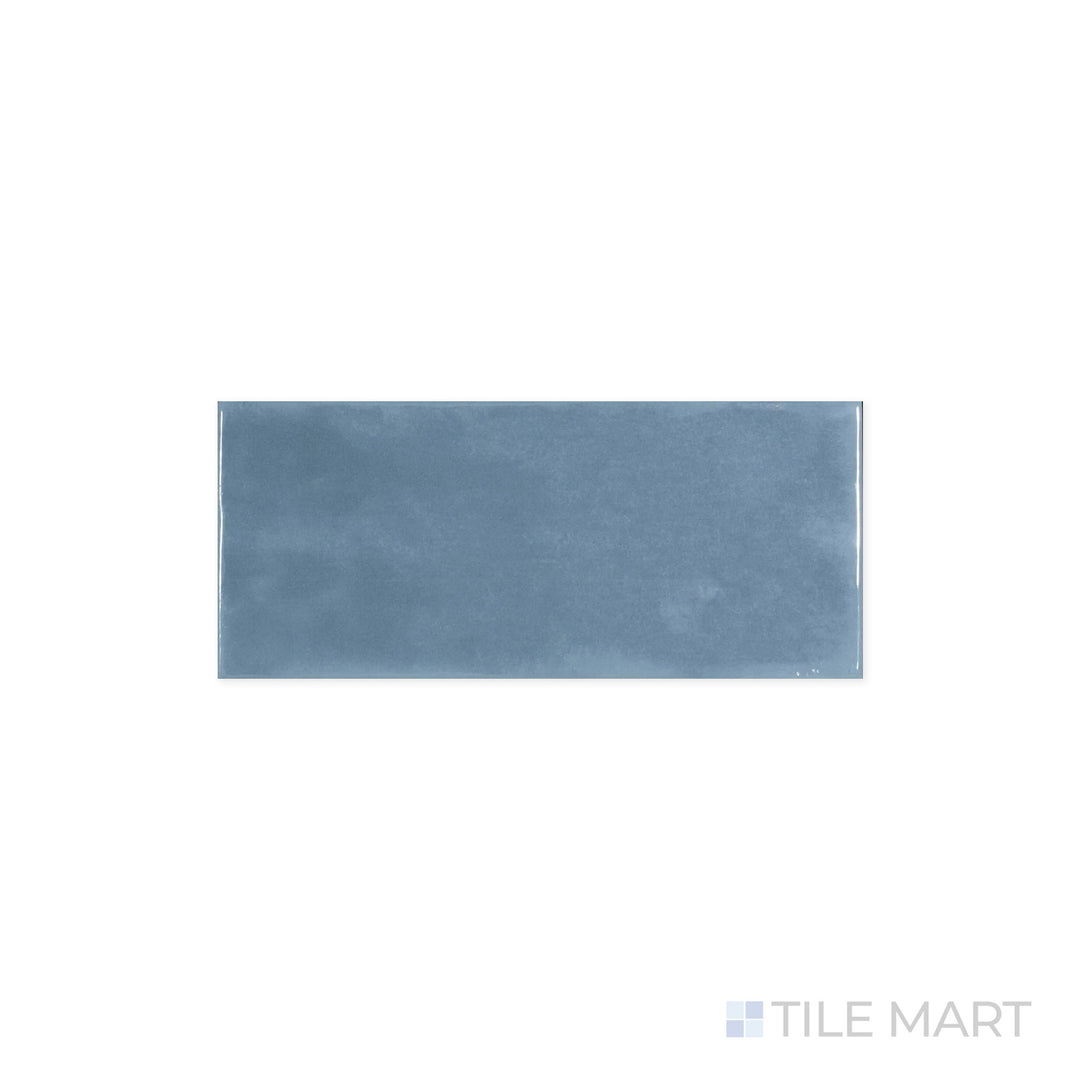 Zoomed-in perspective of Maiolica Blue Steel 4x10 Bright Ceramic Tile, showcasing its deep steel-blue shade and polished finish. The sleek surface catches and enhances surrounding light.