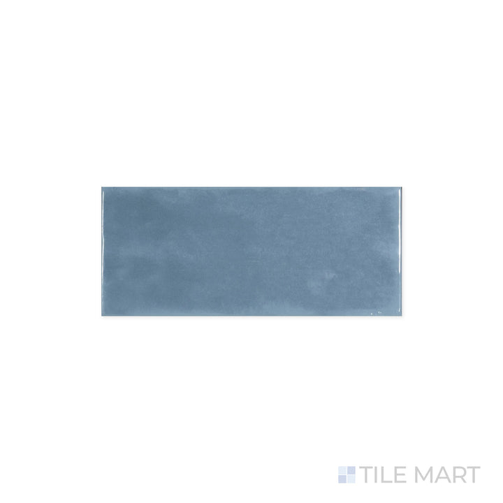 Zoomed-in perspective of Maiolica Blue Steel 4x10 Bright Ceramic Tile, showcasing its deep steel-blue shade and polished finish. The sleek surface catches and enhances surrounding light.