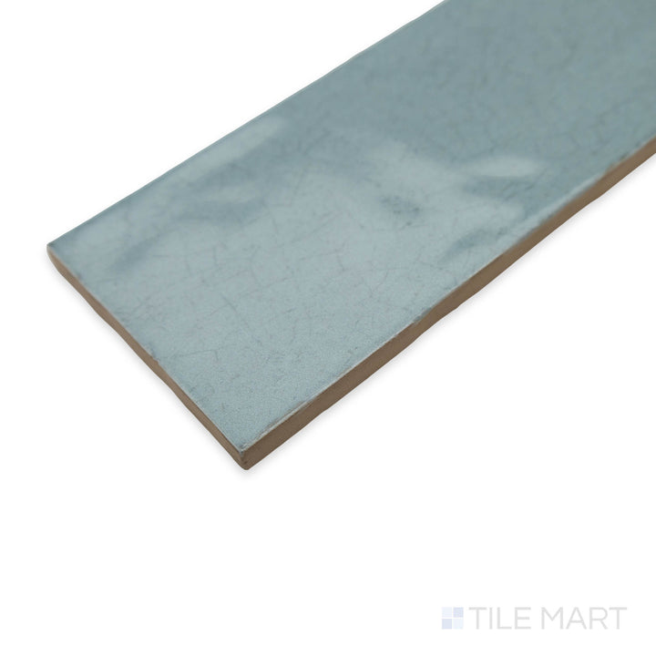 A fresh and vibrant corner view of Maiolica Aqua 3x12 bright ceramic tile, showcasing its cool blue shade and high-shine surface.