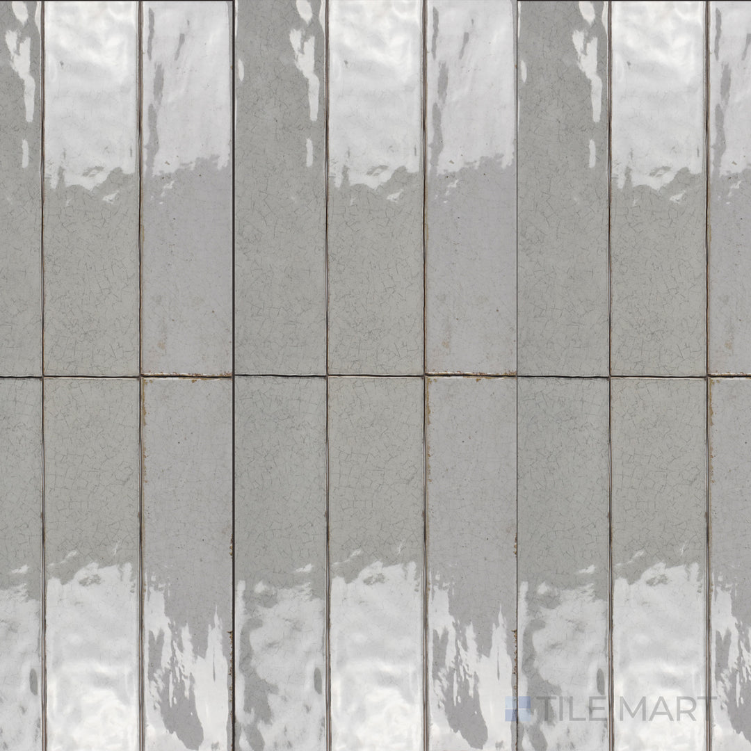 Seen from above, the Maiolica Tender Gray 3x12 inch bright ceramic tile features a soft gray shade with a reflective glaze, offering a subtle and contemporary aesthetic.