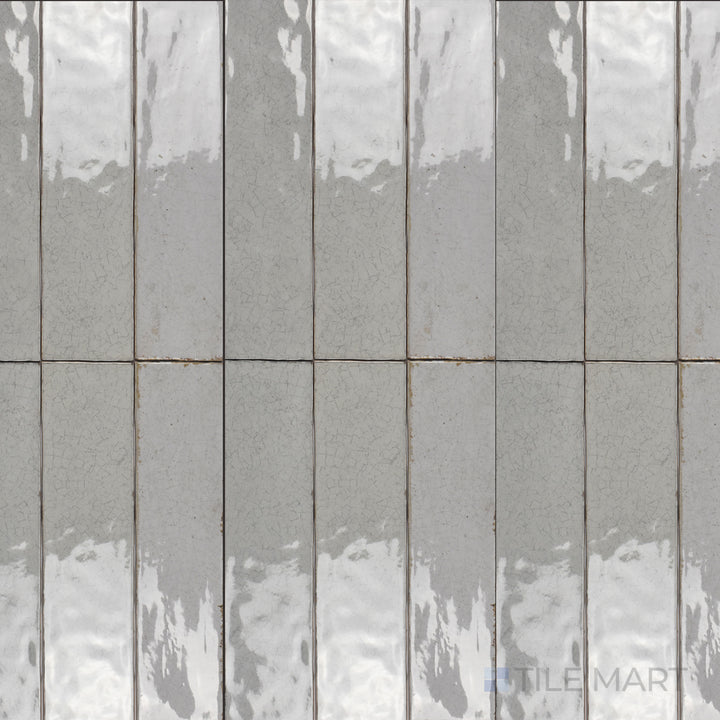 Seen from above, the Maiolica Tender Gray 3x12 inch bright ceramic tile features a soft gray shade with a reflective glaze, offering a subtle and contemporary aesthetic.