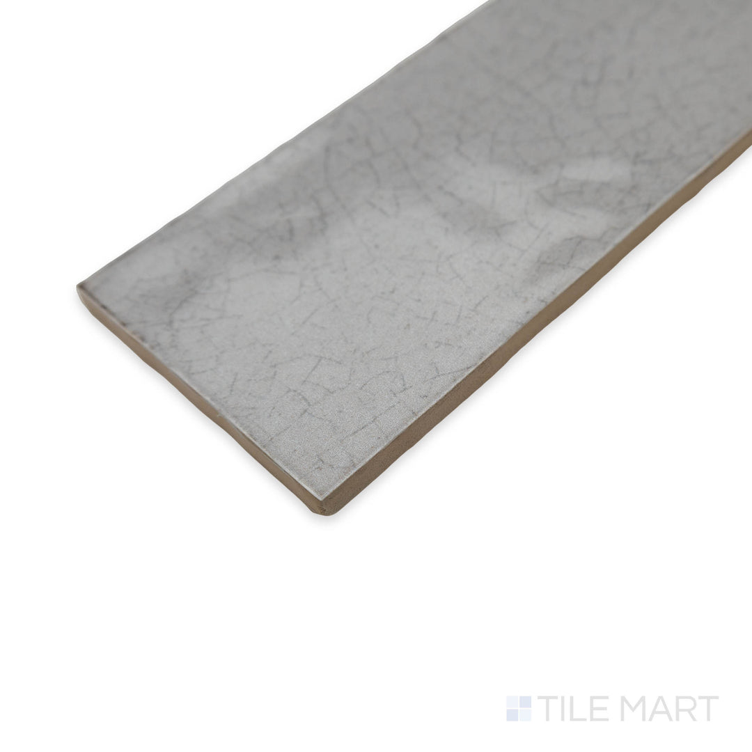 Maiolica Tender Gray 3x12 bright ceramic tile in a close-up corner perspective, displaying its smooth neutral tone and glossy finish for a sleek appeal.