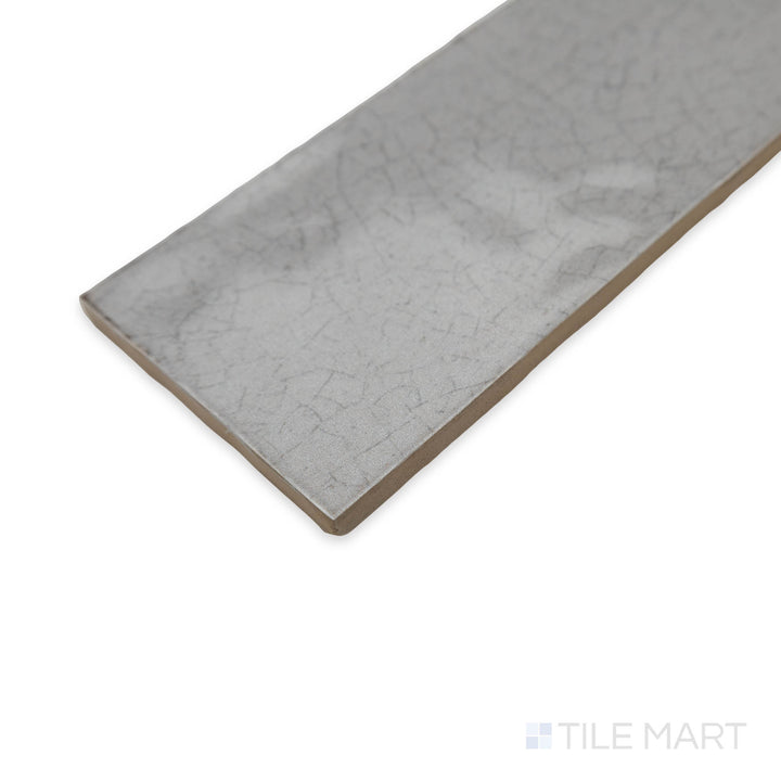 Maiolica Tender Gray 3x12 bright ceramic tile in a close-up corner perspective, displaying its smooth neutral tone and glossy finish for a sleek appeal.