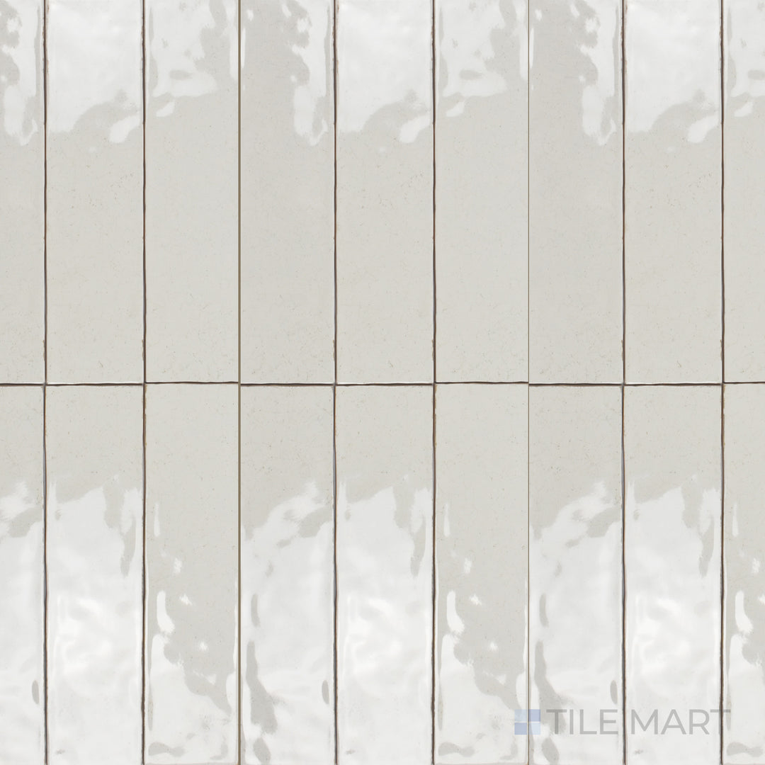 A top-down shot of the Maiolica Biscuit 3x12 inch bright ceramic tile presents its warm beige tone with a high-gloss surface, enhancing a cozy yet elegant ambiance.