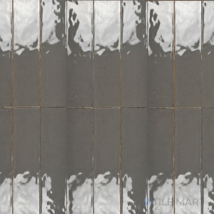 An overhead view of the Maiolica Taupe 3x12 inch bright ceramic tile captures its earthy taupe color and glossy sheen, bringing warmth and sophistication to interiors.