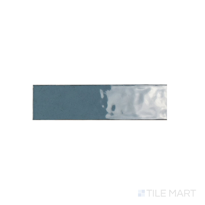 A focused close-up of Maiolica Blue Steel 3x12 Bright Ceramic Tile, highlighting its deep steel-blue shade with a sleek, polished surface. The glossy finish amplifies richness and shine.