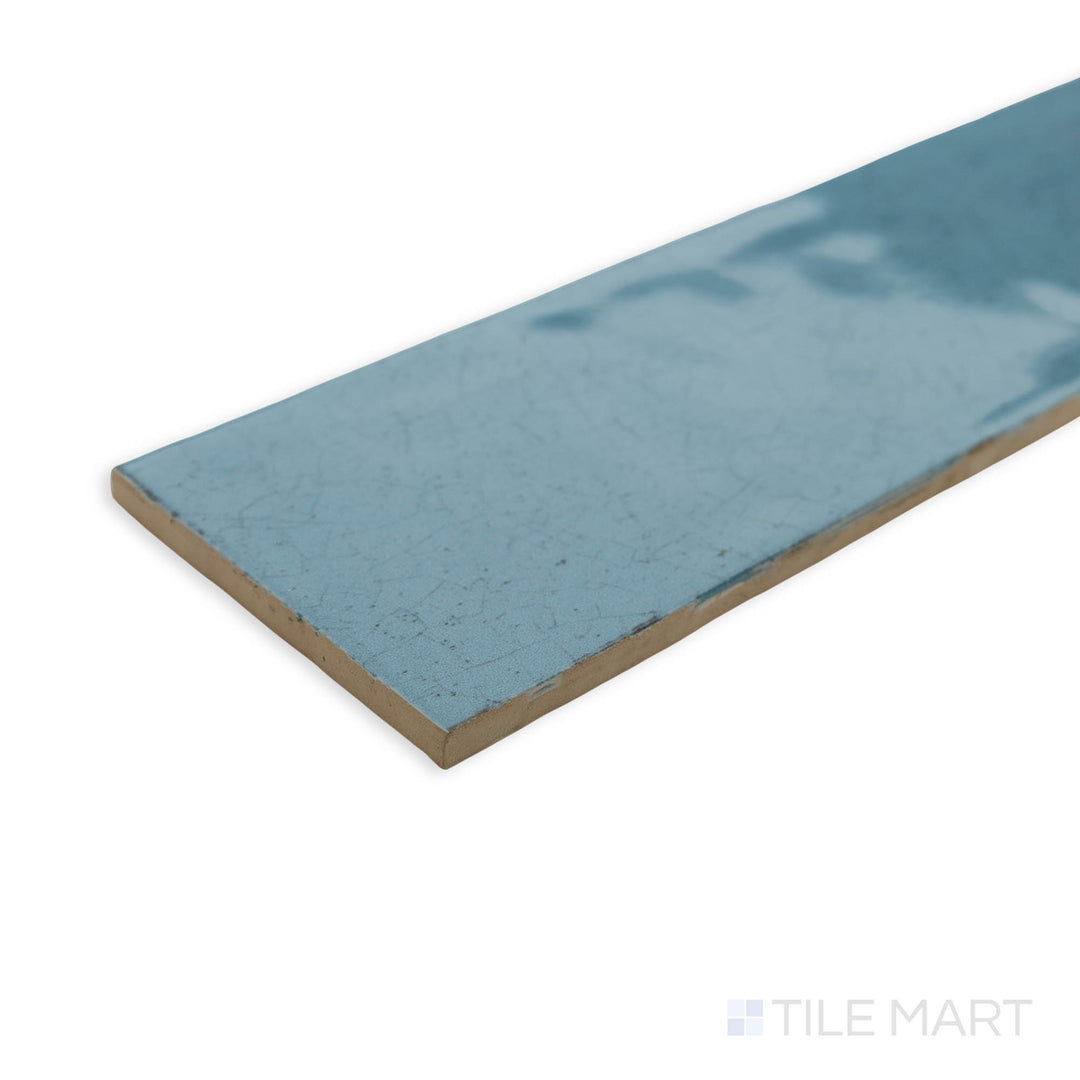 A bold and contemporary corner view of Maiolica Blue Steel 3x12 bright ceramic tile, showcasing its deep steel-blue shade and sleek glossy finish.