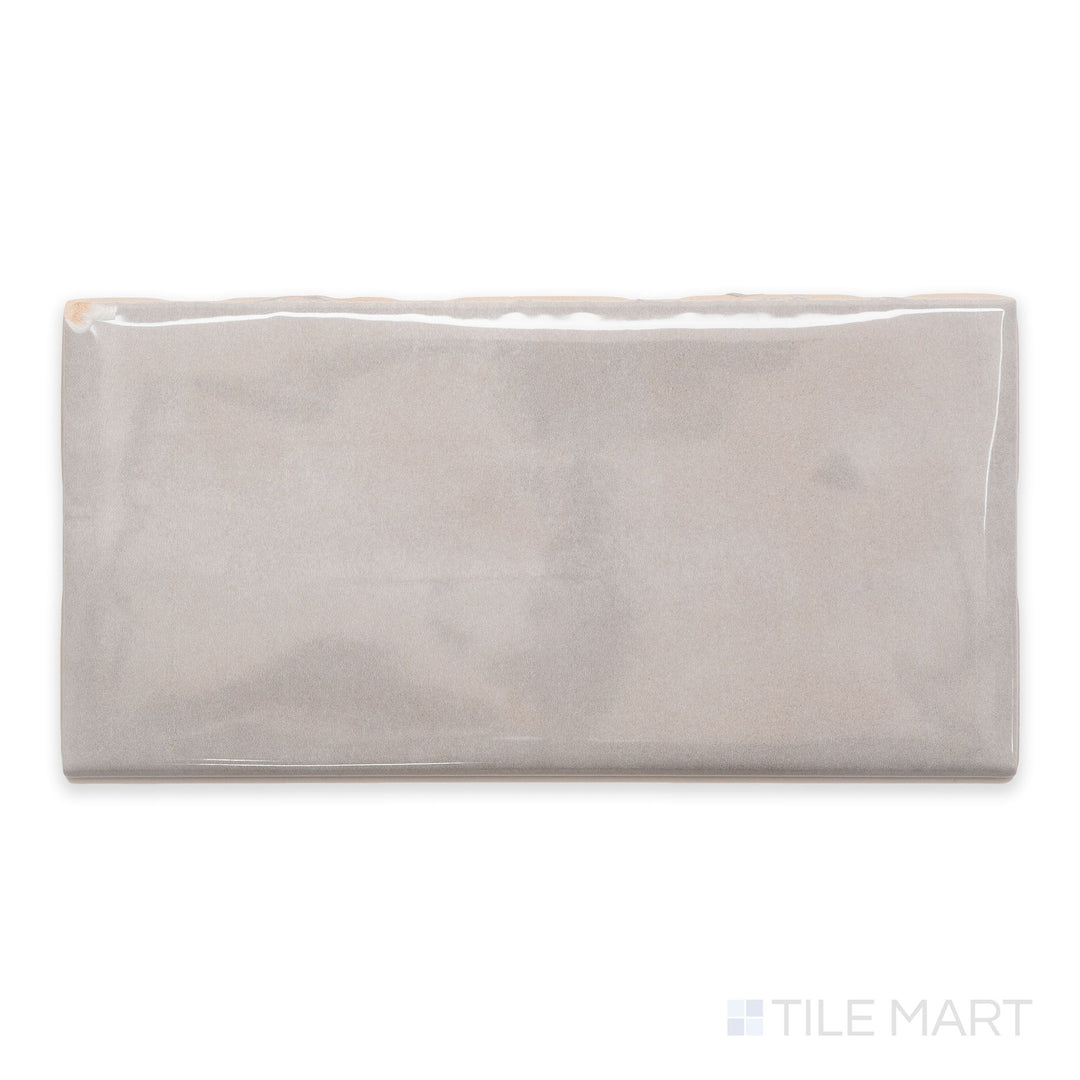 A top-down view of Maiolica Tender Gray 3x6 bright ceramic bullnose, showcasing its subtle gray color and glossy, refined finish.