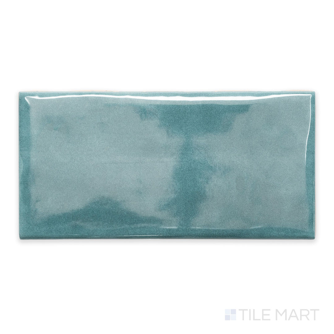 A detailed top-down view of Maiolica Blue Steel 3x6 bright ceramic bullnose, emphasizing its deep blue-gray shade and reflective ceramic surface.