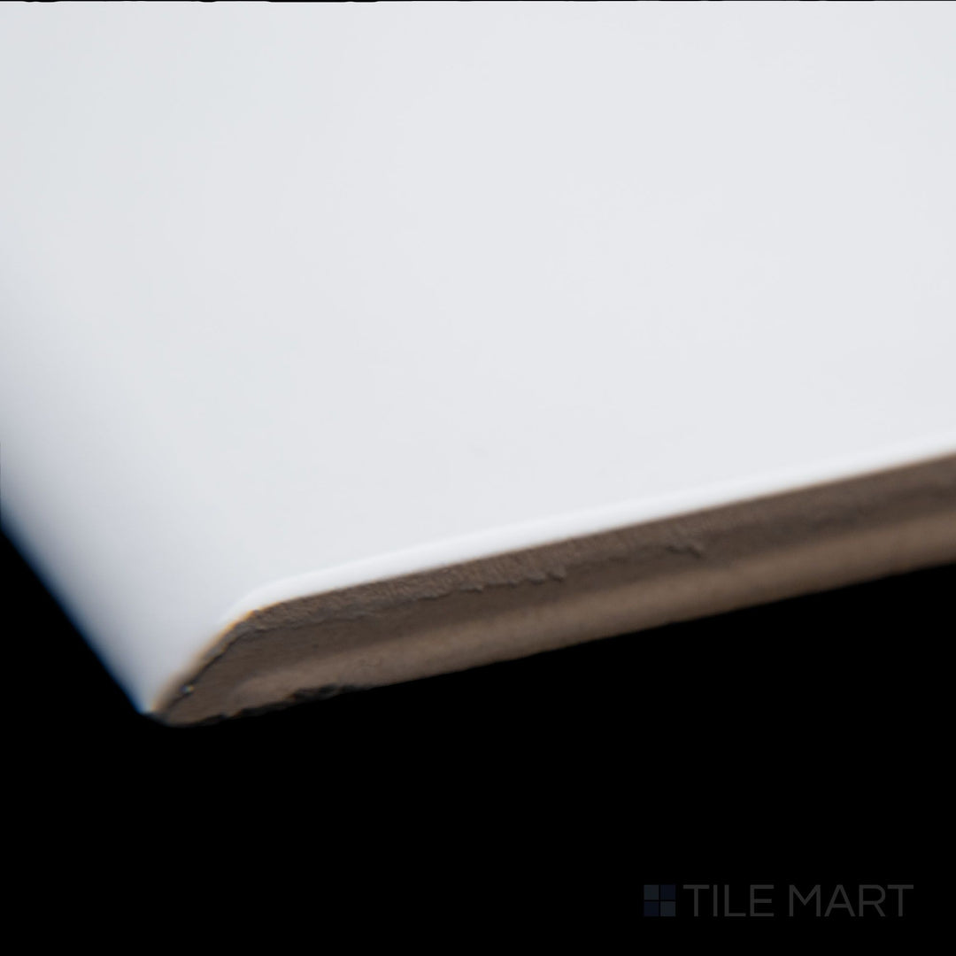 A close-up corner shot of Maiolica White 3X10 bright ceramic bullnose, highlighting its bright white tone, rounded bullnose edge, and smooth glazed surface.