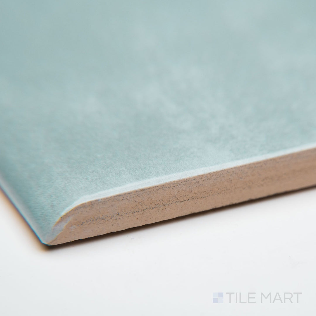 A close-up of Maiolica Aqua 3X10 bright ceramic bullnose, showcasing its bold aqua hue, smooth bullnose edge, and high-gloss ceramic glaze.