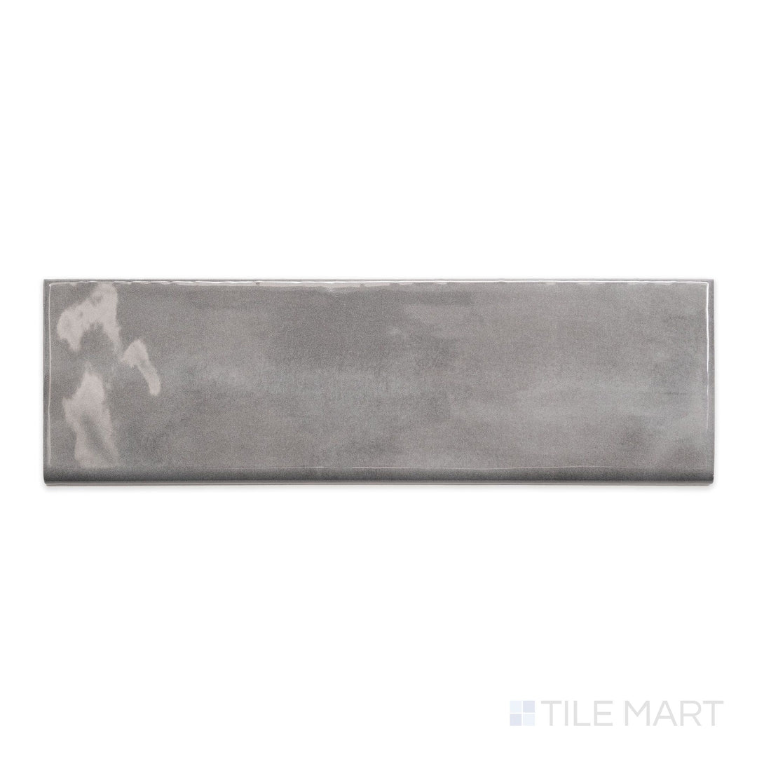 A detailed top-down view of Maiolica Taupe 3x10 bright ceramic bullnose, emphasizing its earthy taupe shade and polished finish.