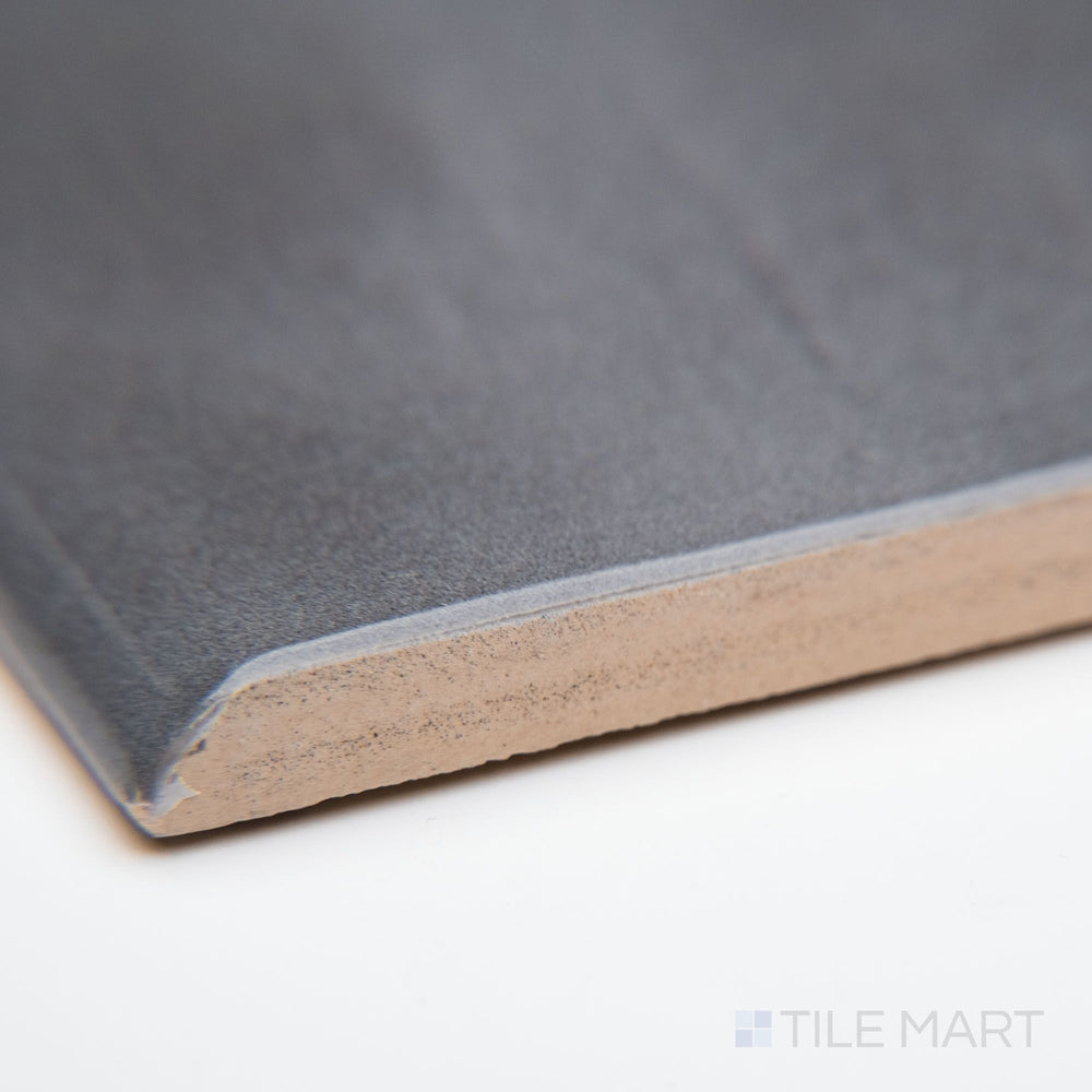 A close-up of Maiolica Taupe 3X10 bright ceramic bullnose, featuring an earthy taupe hue, polished edge, and sleek glossy finish.