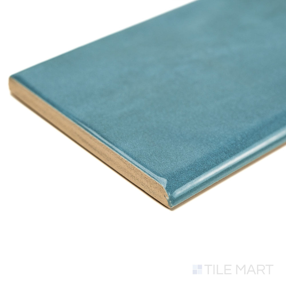 Angled corner shot of Maiolica Blue Steel 3x10 Bright ceramic bullnose tile, showing its glossy blue finish and refined bullnose edge for seamless edge applications.