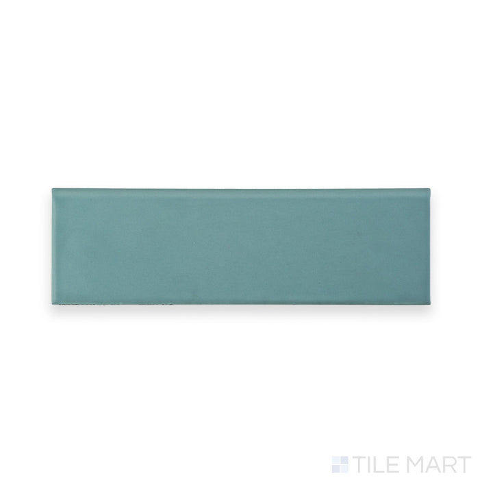 Captured from above, the Maiolica Aqua 3x10 Matte ceramic bullnose tile shows off its subtle matte glaze and cool aqua color with curved edge.