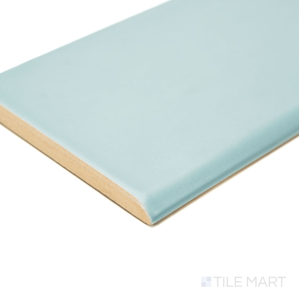 Corner image of Maiolica Aqua 3x10 Matte ceramic bullnose tile, featuring a soft aqua matte glaze and curved trim—great for clean edge detail in wall designs.